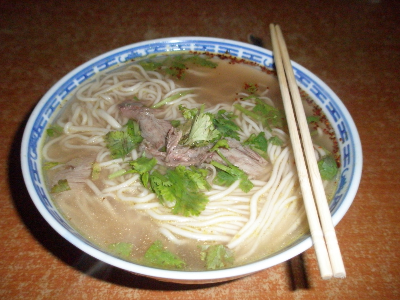 A bowl of Lanzhou beef noodle soup, hand-pulled noodles in a clear broth